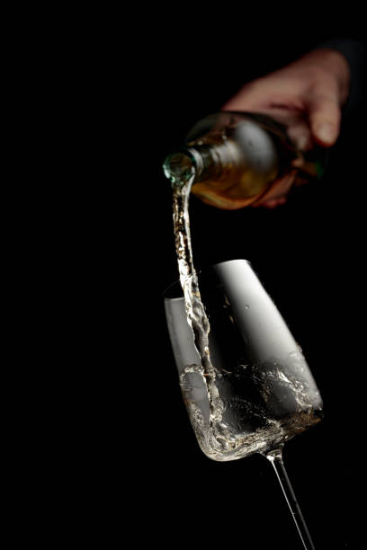 istock Pouring white wine in a glass goblet. 2160244757