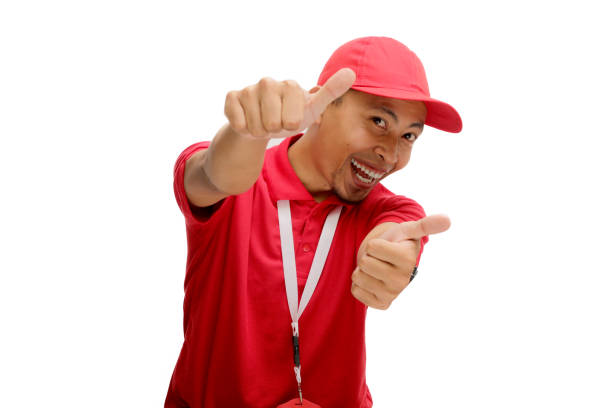 Excited Asian Delivery man or courier is showing thumb up gesture at the camera, Isolated on a white background