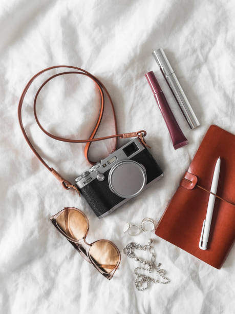 istock Aesthetic details, women's accessories - retro camera, leather notebook, sunglasses, cosmetics on a light background, top view 2160252215