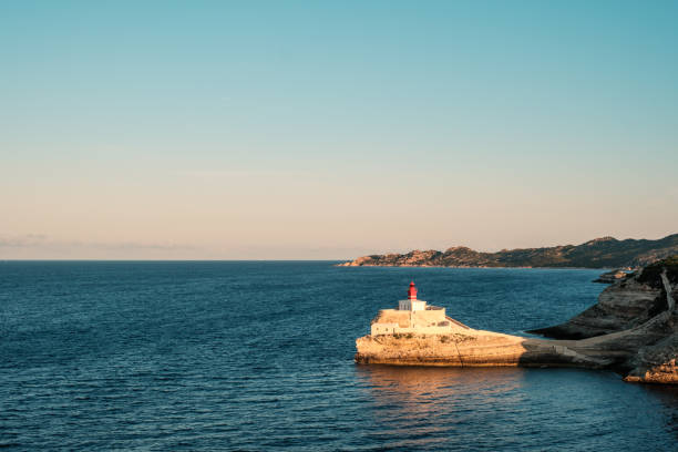 Early morning sun on Phare de la Madonetta, a lighthouse on a limestone promontory at the entrance to the harbour at Bonifacio in Corsica