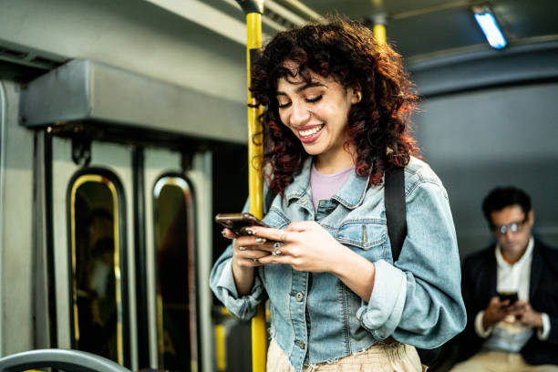 Young woman using mobile phone on bus