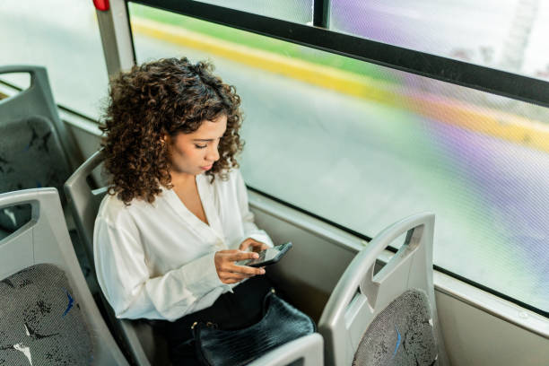 istock Young woman using mobile phone on bus 2160254014