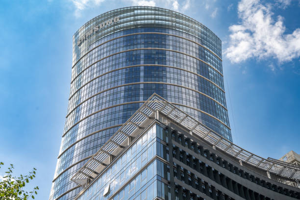 18.06.2024 Warsaw, Poland. The sleek, modern Warsaw Spire office building stands tall under a clear blue sky, prominently featuring the Samsung logo at the top. Samsung has established a Mobile B2B Innovation Center within this building, designed to cater to business customers by showcasing cutting-edge technology and solutions. The building's glass facade harmoniously reflects the vibrant sky, creating an impressive blend of architecture and environment.