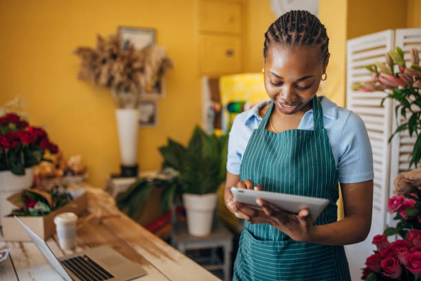 istock Florist multitasking with tablet in cozy flower shop 2160257527