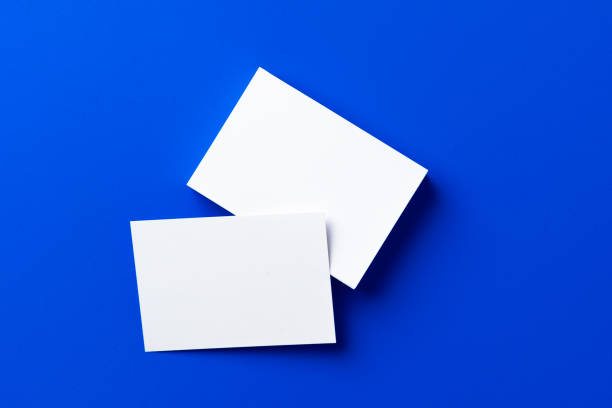 istock Blank white businesscards on classic blue background 2160258723