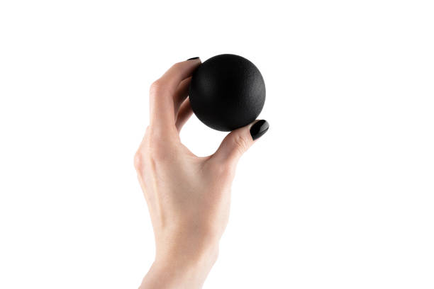 istock Massage black ball in female hand for trigger points isolated on a white background. Concept of myofascial release. 2160261512
