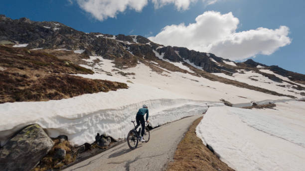 Road biker rides up high mountain pass