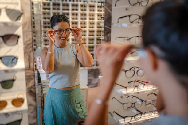 Beautiful Woman choosing glasses in optical store