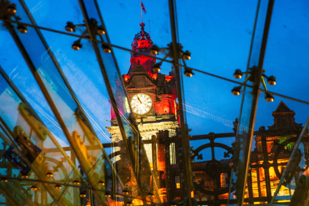 The Clock Tower of the Balmoral hotel seeing through the glass roof of Waverly Station at the dusk