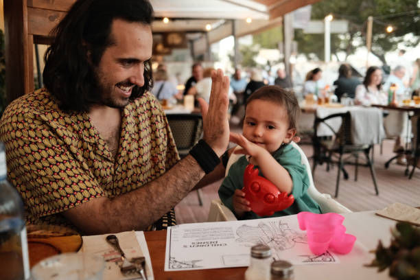 istock Happy father and son giving high five in restaurant 2160265045