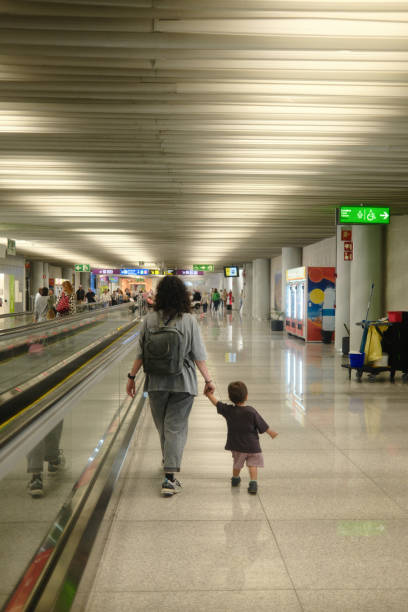 istock Mother and son walking through airport terminal holding hands 2160265986