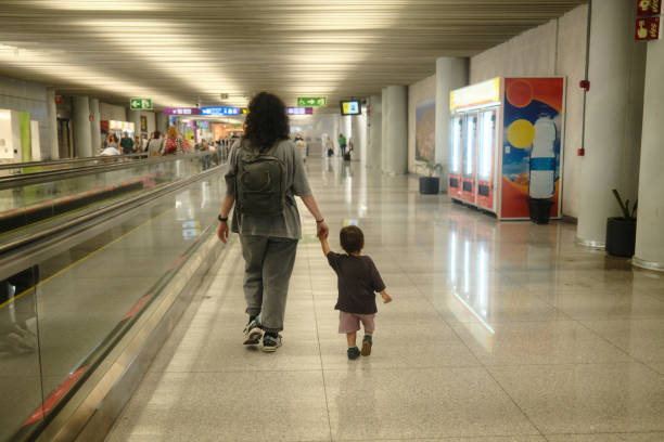 istock Mother and son walking through airport terminal 2160265990
