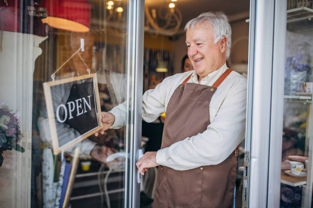 istock Elderly shopkeeper opening store with a smile on face. 2160267250