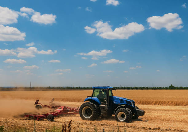 istock tractor plows a field with wheat on a farm 2160268753