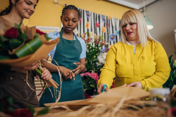 istock Florists collaborating to wrap a floral bouquet creatively. 2160272539