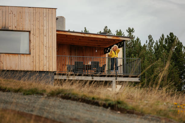 istock Stylish woman on mountain cabin deck 2160272696