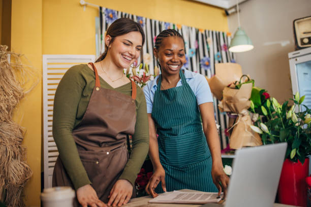 istock Florists discussing work while using laptop in flower shop. 2160273194