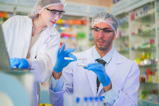 istock scientists perform experiments and record data. people arranges equipment with test tubes and chemicals for producing medicine and biochemistry. man hold tubes of chemical liquids and plant samples. 2160273397