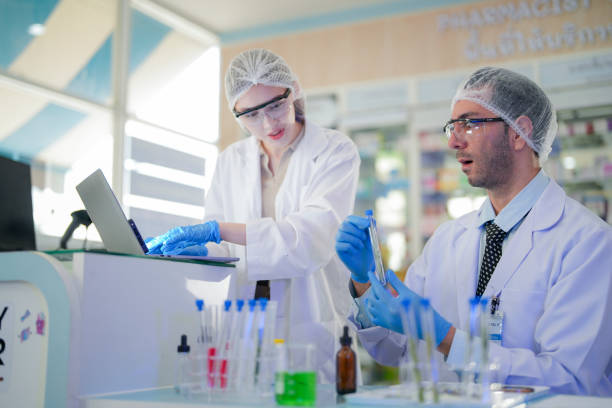 istock scientists perform experiments and record data. people arranges equipment with test tubes and chemicals for producing medicine and biochemistry. man hold tubes of chemical liquids and plant samples. 2160273481