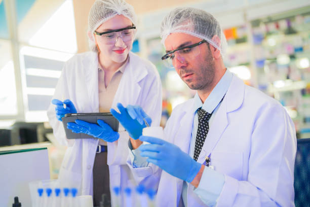 istock scientists perform experiments and record data. people arranges equipment with test tubes and chemicals for producing medicine and biochemistry. man hold tubes of chemical liquids and plant samples. 2160273991