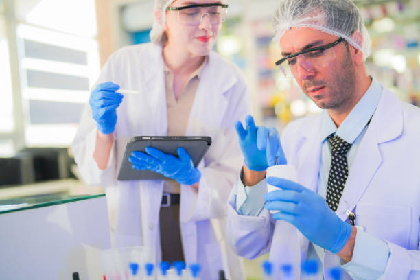 istock scientists perform experiments and record data. people arranges equipment with test tubes and chemicals for producing medicine and biochemistry. man hold tubes of chemical liquids and plant samples. 2160275185