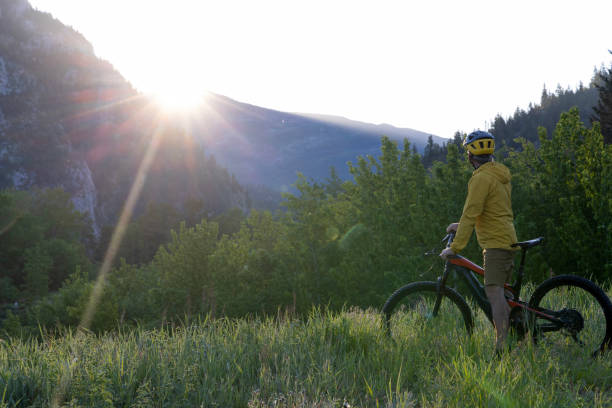 istock Mountain biker looks towards sunrise over mountains 2160275524