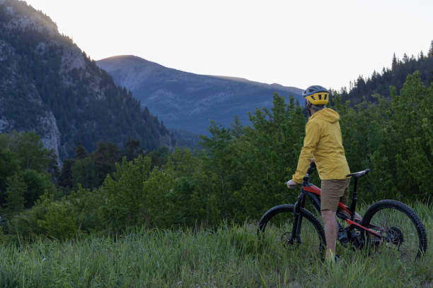istock Mountain biker looks towards sunrise over mountains 2160275599