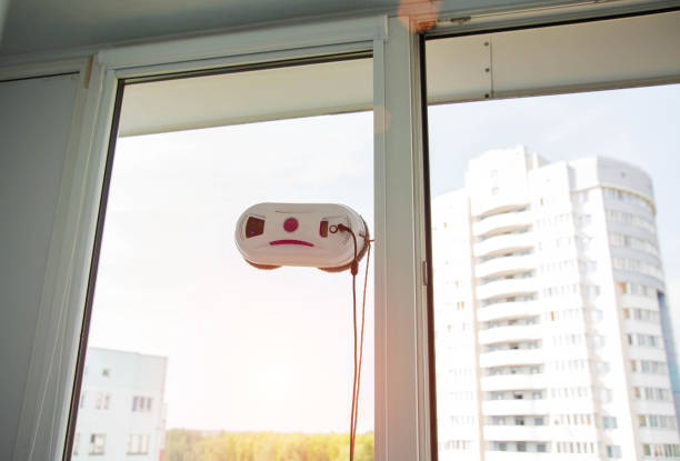 istock Automatic vacuum robot window cleaner washes glass in the apartment, balcony frame, 2160275895