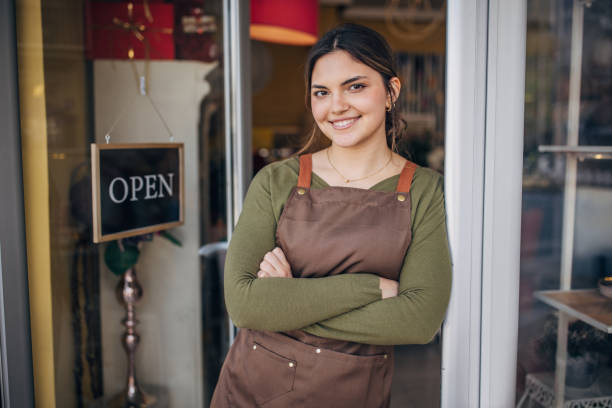 istock Happy florist posing outside her open flower shop 2160276353