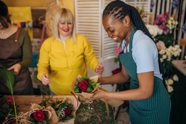 istock Instructor and students happily arranging fresh red roses. 2160276733