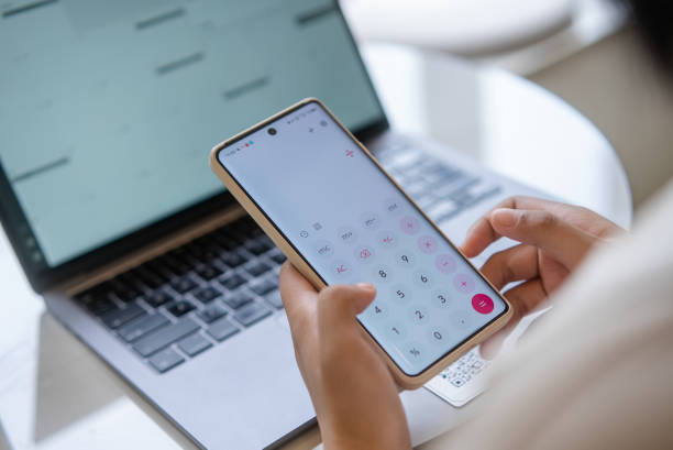 istock Women use mobile phone calculators. 2160278702