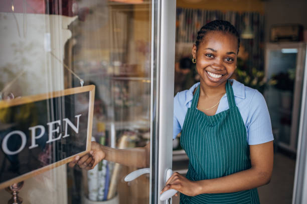 istock Smiling florist opening a flower shop 2160278979