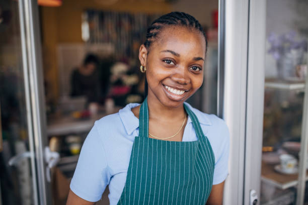 istock Smiling florist posing outside shop with green apron 2160279033
