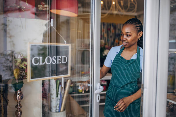 istock Smiling florist posing outside shop with green apron on 2160279249