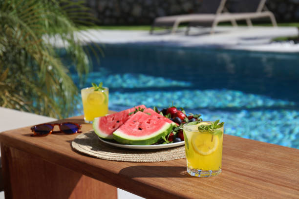 istock Fruits and berries with lemonade by the pool. 2160288635