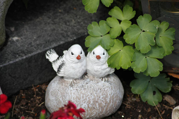 Two stone birds sitting on a stone