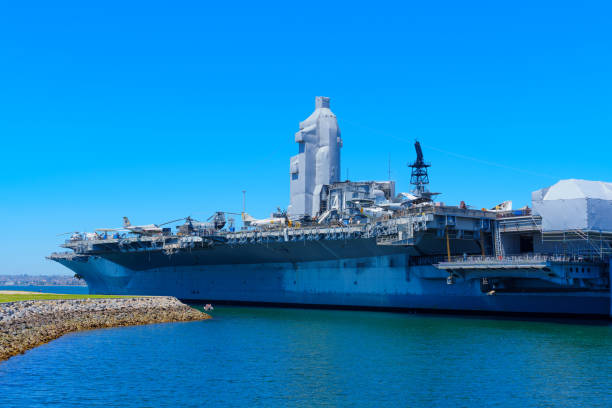 San Diego, California - April 16, 2024: Large aircraft carrier docked in San Diego harbor on a sunny day.