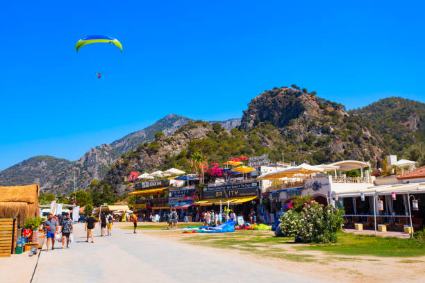 Oludeniz, Turkey - July 13, 2022: Flying paraglider at the centre of Oludeniz or Blue Lagoon beach in the Fethiye district of Mugla Province, Turkey.