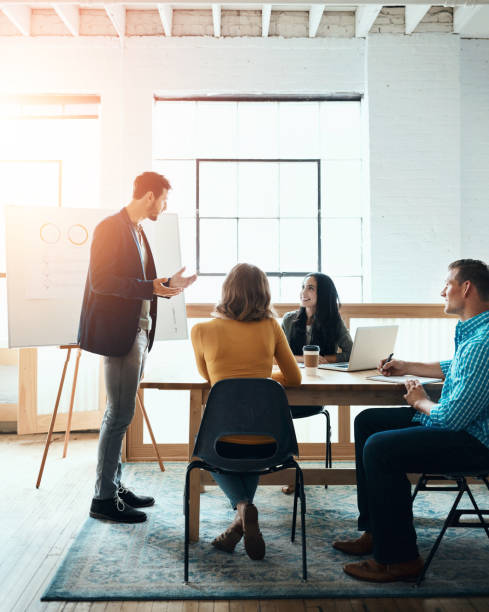 Business people, group and leader with presentation for coaching, meeting and brainstorming. Presenter, creative and manager training team with data, analysis and stats for news editor in startup