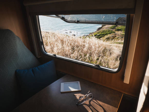 istock E-book reader and glasses by the motor home window with views to nature 2160300541
