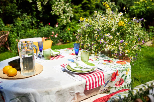 istock Bright summer holiday table setting in nature in the backyard, the table is decorated with wildflowers, daisies and fruits 2160307948