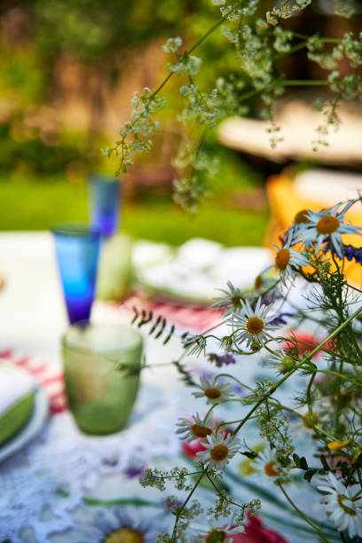 istock Bright summer holiday table setting in nature in the backyard, the table is decorated with wildflowers, daisies and fruits 2160309716