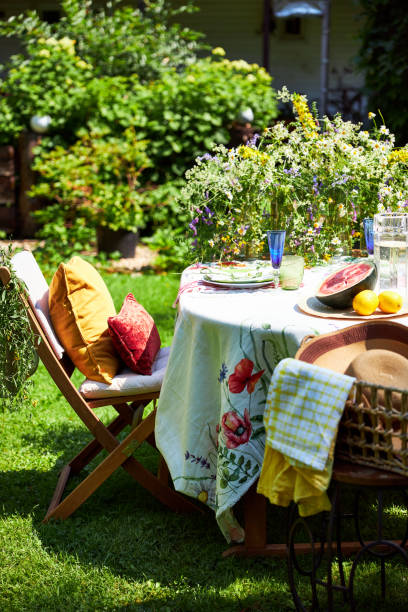 istock Bright summer holiday table setting in nature in the backyard, the table is decorated with wildflowers, daisies and fruits 2160310191