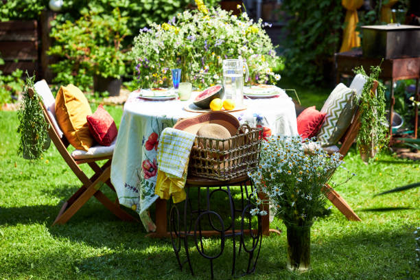 istock Bright summer holiday table setting in nature in the backyard, the table is decorated with wildflowers, daisies and fruits 2160310403