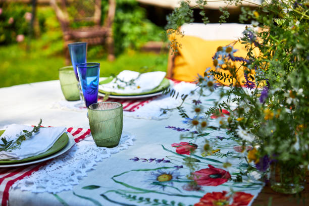 istock Bright summer holiday table setting in nature in the backyard, the table is decorated with wildflowers, daisies and fruits 2160310898