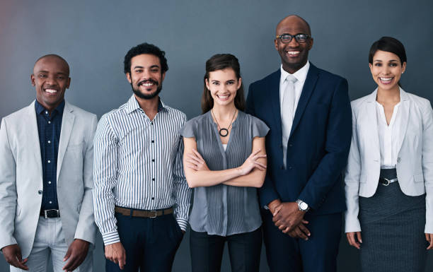 istock About us, people and happy on portrait in studio on grey background with pride for teamwork and collaboration. Employee, diversity and smile with confidence for partnership, project and business 2160311391