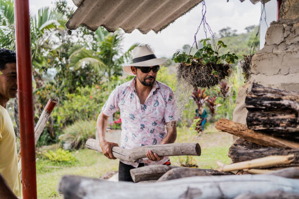 Mature man putting firewood on oven