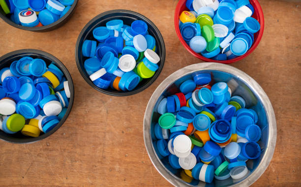 High angle view of a collection of multi colored bottle caps in bowls on a floor waiting to be recycled into something new