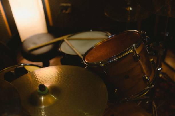 istock Close-up view of a drum set with drumsticks in a dimly lit recording studio 2160319629