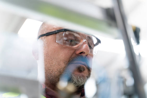 Male industrial worker working with manufacturing equipment in a cable factory, close up stock photo